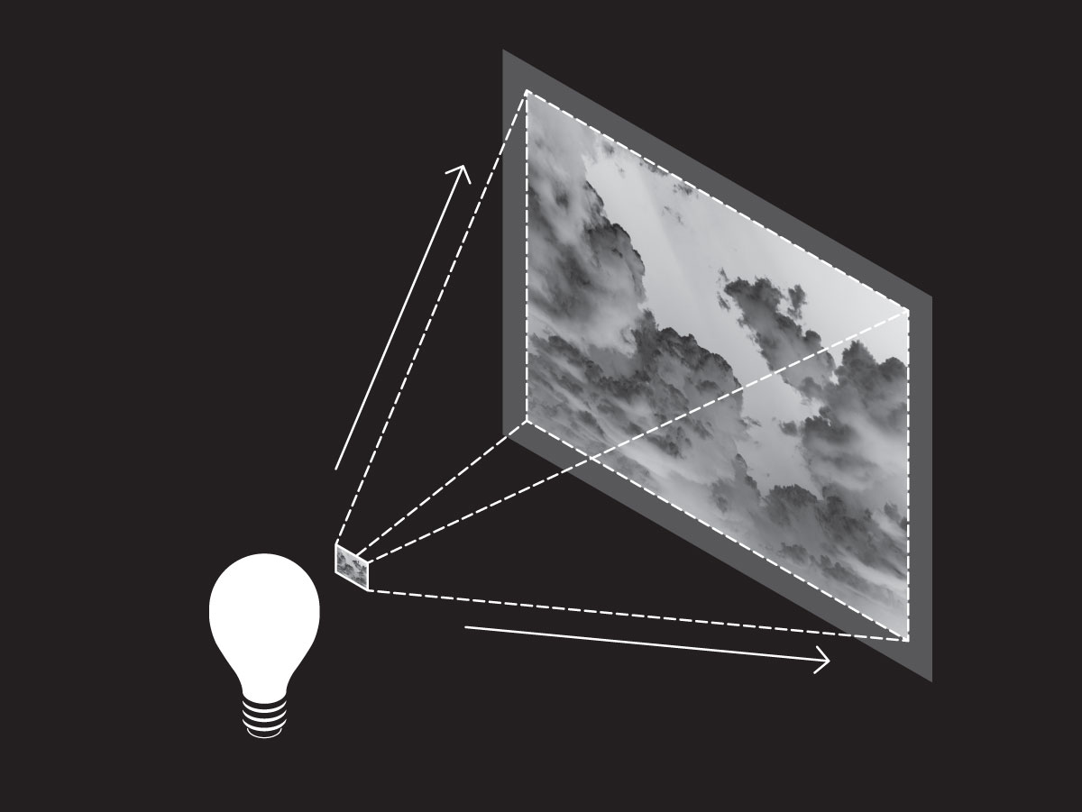 A lightbulb in front of a small photographic negative on a dark background. White dotted lines indicating light travel outward from each corner of the negative to frame a larger projection of the image.