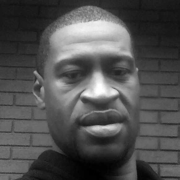 A photograph of George Floyd, a Black man, standing in front of a brick wall